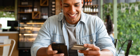 man smiling with his card and phone