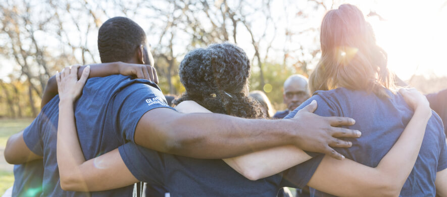 People arm in arm in sunshine