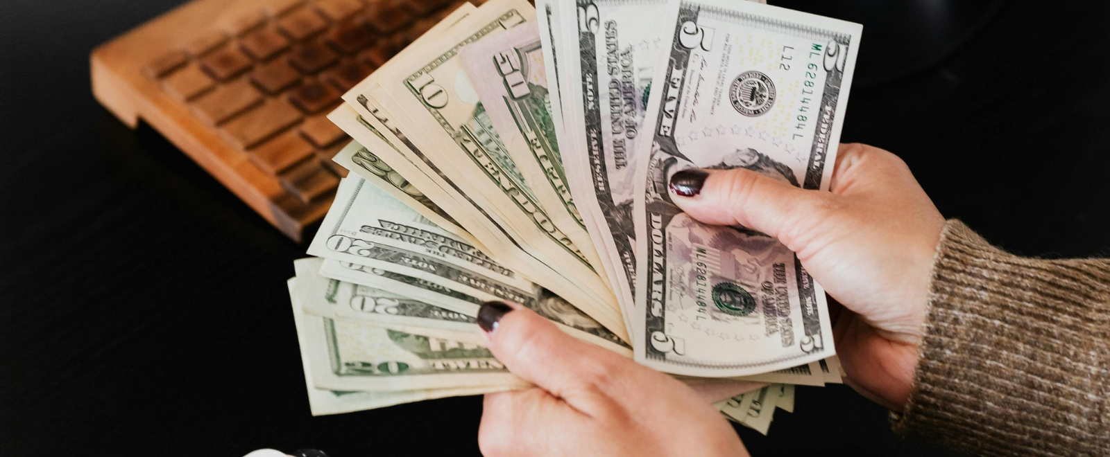 Person fanning out multiple denominations of bills